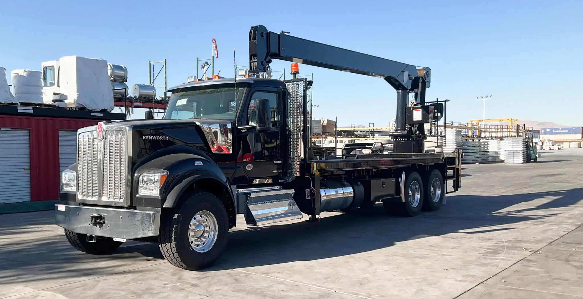 Black QMC 4033R rear-mounted boom truck crane with extended long boom and three axles, showcasing heavy-duty boom truck cranes built for lifting power.